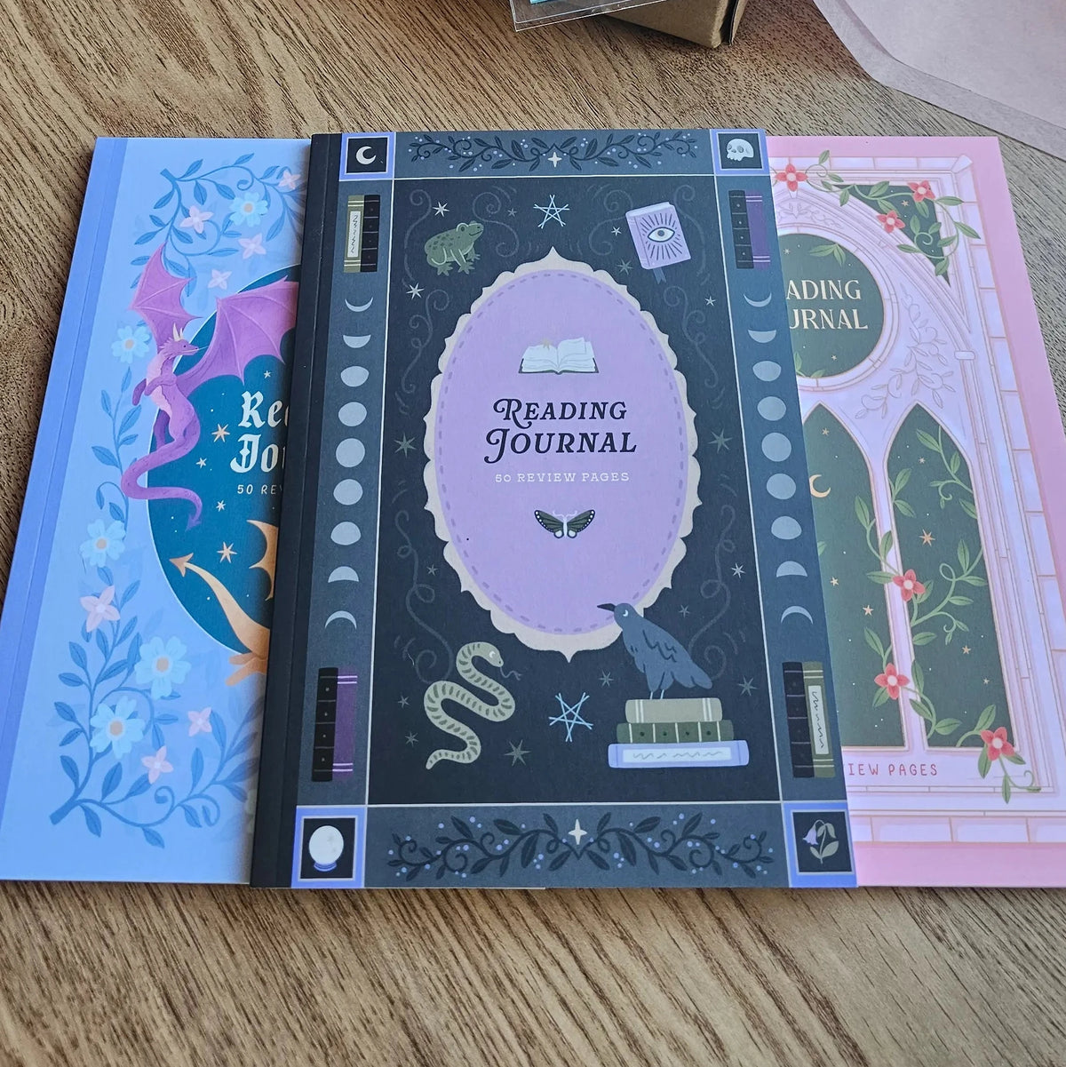 Spread Those Pages Book Reviewer Bundle with Dark Academia Reading Journal featuring gothic raven and snake design, Fantasy Romance blind date book box, annotation tabs and washi tape