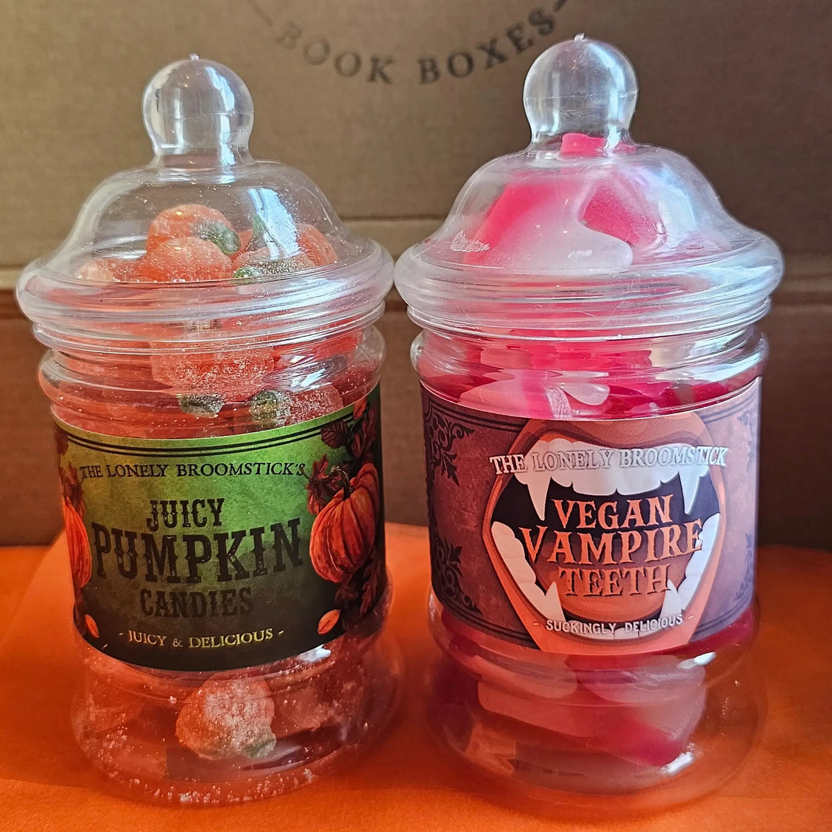 "Two Halloween sweet jars from The Lonely Broomstick — Juicy Pumpkin Candies and Vegan Vampire Teeth — included in the Spread Those Pages Halloween book box"