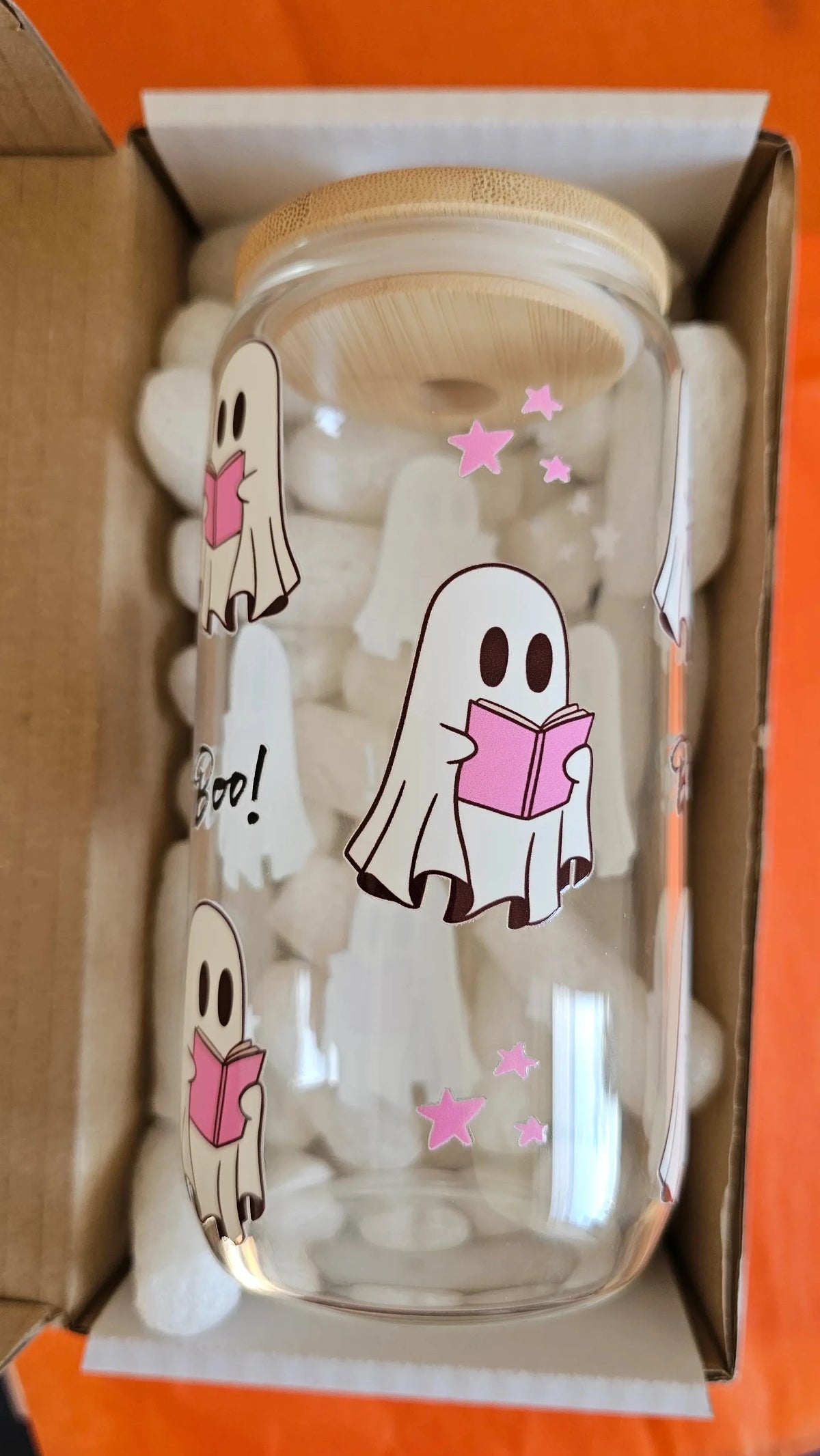 Halloween ghost reader glass tumbler with bamboo lid and glass straw on orange background"